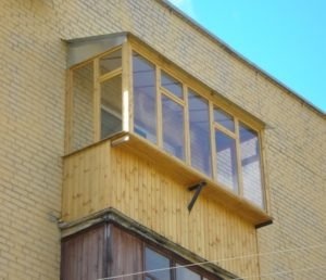 Балкон с деревянными окнами
